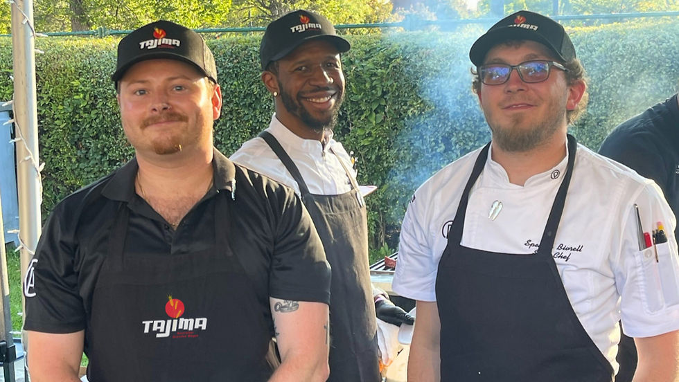 Chefs cooking outside wearing Tajima Australian Wagyu aprons and hats cooking a steak