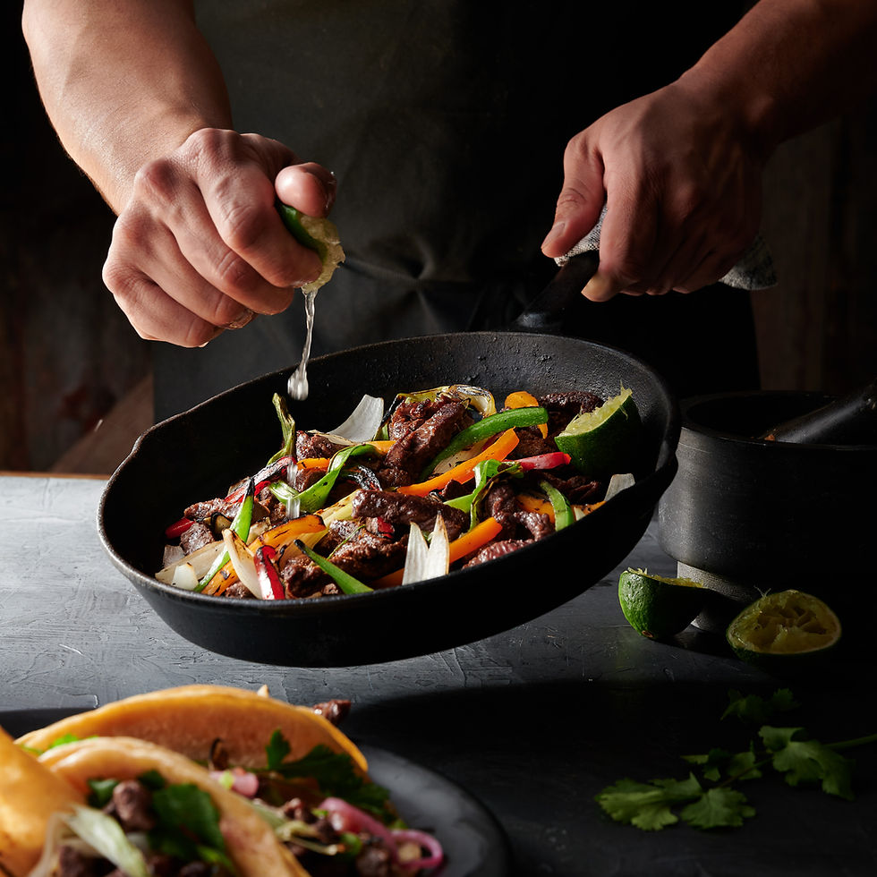 chef squeezing lime on australian beef fajita in a skillet