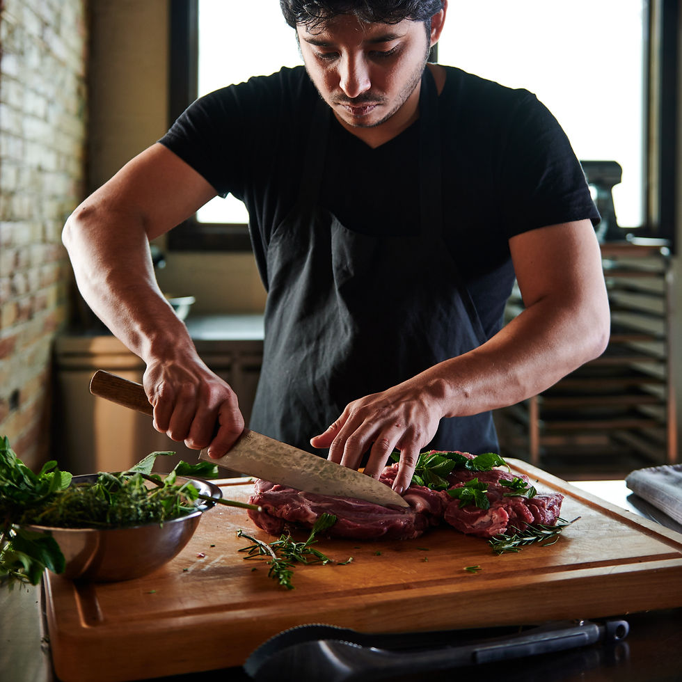a chef cutting meat for kitchen prep in his restaurant